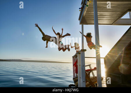 Junge Erwachsene Freunde von Sommer Hausboot in sonnigen Meer springen Stockfoto