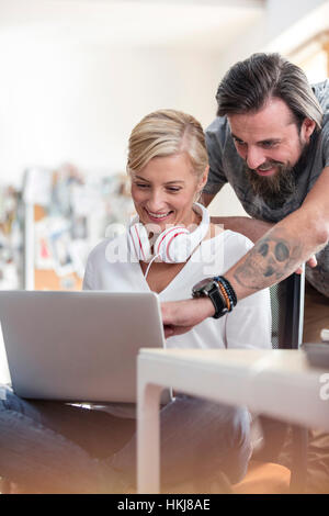 Lächeln auf den Lippen Design-Profis arbeiten am Laptop im Büro Stockfoto