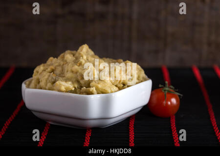 Auberginen-Salat mit Mayonnaise und Zwiebel und eine Kirschtomate auf Teppich Stockfoto