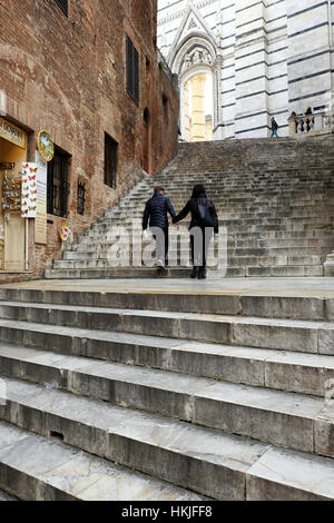 Teen Liebe - zwei Teenager in Liebe Hand in Hand - jungen und Mädchen Hand in hand gehen auf Treppe - Kathedrale von Siena, Toskana, Italien Stockfoto