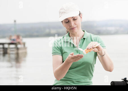 Reife Frau, die Anwendung von Sonnencreme von See, Bayern, Deutschland Stockfoto