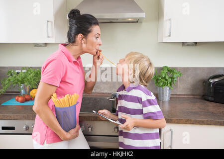 Frau mit ihrem Sohn spielen mit Spaghetti in Küche, Bayern, Deutschland Stockfoto