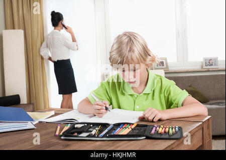 Junge studiert, während Mutter Business Call, Bayern, Deutschland hat Stockfoto