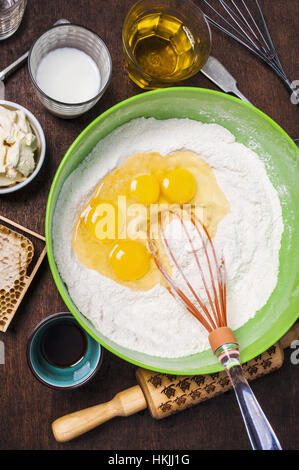 Zutaten und Werkzeuge, um einen Kuchen - Mehl, Butter, Milch, Eiern, Honig, Olivenöl Stockfoto