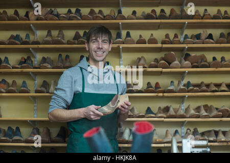 Porträt von ein Schuh-Hersteller mit einer Schuh trage in Workshop, Freiburg Im Breisgau, Baden-Württemberg, Deutschland Stockfoto