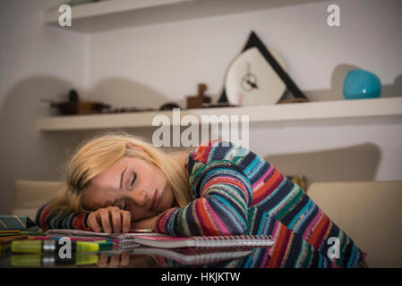 Erschöpft Schüler schlafen während der Hausaufgaben im Wohnzimmer, Bayern, Deutschland Stockfoto