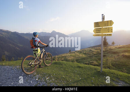 Rückansicht der Mountainbiker in die alpine Landschaft stehen und betrachten während Sonnenuntergang, Zillertal, Tirol, Österreich Stockfoto