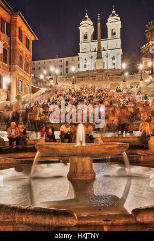 Touristen sitzen auf der spanischen Treppe an Brunnen, Piazza di Spagna, Rom, Italien Stockfoto