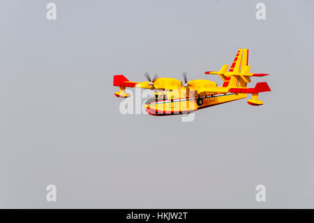 Gelbe und rote Canadair Wasser Bomber, Turbo Prop Feuerwehr Flugzeug in Aktion, banking, Kugel-Wasser vom Meer Stockfoto