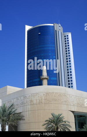 Minarett der Beit al-Quran gesehen gegen die Fassade des modernen Bürohochhaus im diplomatischen Bereich, Bahrain Stockfoto