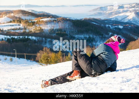 Mädchen gefallen nach unten auf den verschneiten Berg Stockfoto