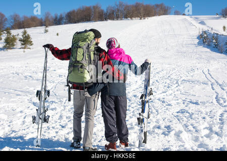 Paar mit Skiern auf dem schneebedeckten Berg Stockfoto