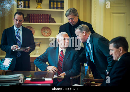 Washington DC, USA. 28. Januar 2017. US-Vize-Präsident Mike Pence spricht mit White House Pressesprecher Sean Spicer als Präsident Donald Trump mit Präsident von Rußland Vladimir Putin am Telefon im Oval Office in Washington, DC spricht. Der Aufruf war einer der fünf Gespräche mit ausländischen Führern für Samstag geplant. White House Chief Of Staff Reince Priebus. Chief Strategist Stephen K. Bannon und National Security Advisor Michael Flynn waren auch im Zimmer. Bildnachweis: MediaPunch Inc/Alamy Live-Nachrichten Stockfoto