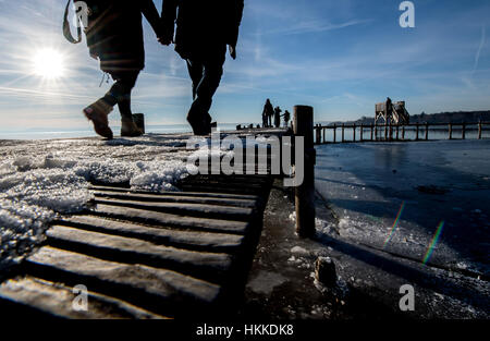 Herrsching, Deutschland. 28. Januar 2017. Menschen schlendern über einen Steg auf dem Ammersee See in der Nähe von Herrsching, Deutschland. Bildnachweis: Dpa/Alamy Live-Nachrichten Stockfoto