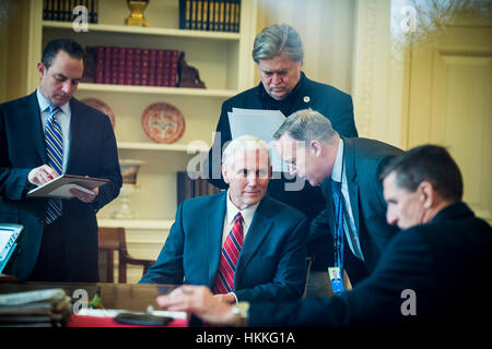 Washington DC, USA. 28. Januar 2017. US-Vize-Präsident Mike Pence spricht mit White House Pressesprecher Sean Spicer als Präsident Donald Trump spricht mit dem Präsidenten der Russischen Föderation, Vladimir Putin am Telefon im Oval Office am 28. Januar 2017 in Washington, DC, der Anruf war einer der fünf Gespräche mit ausländischen Führern für Samstag geplant. White House Chief Of Staff Reince Priebus. Chief Strategist Stephen K. Bannon und National Security Advisor Michael Flynn waren auch im Zimmer. Bildnachweis: Dpa picture Alliance/Alamy Live News Stockfoto