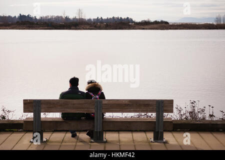 Paar auf Bank am Wasser sitzen.  Steveston, BC. Kanada Stockfoto