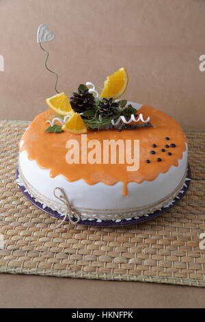 Orange-Kuchen mit Dekoration auf Kraftpapier Stockfoto