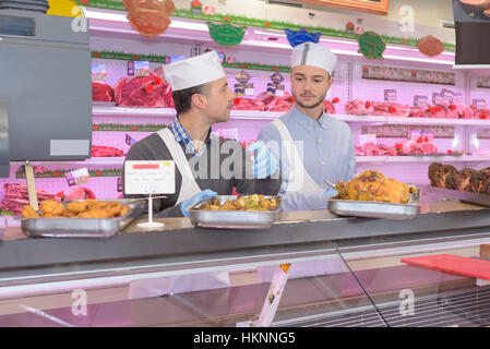 Metzger hinter der Theke in einem Supermarkt Stockfoto