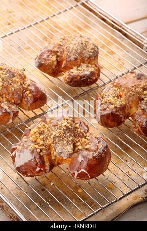 Frische Croissants aus dem Ofen und mit Zuckerglasur und Nüssen verziert Stockfoto