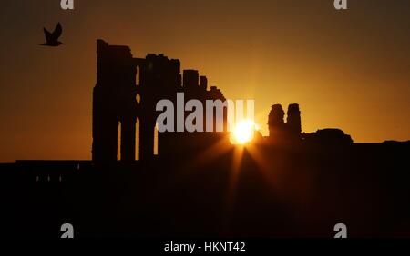 Die Sonne geht über Tynemouth Priory auf die an der Nordost-Küste. Stockfoto