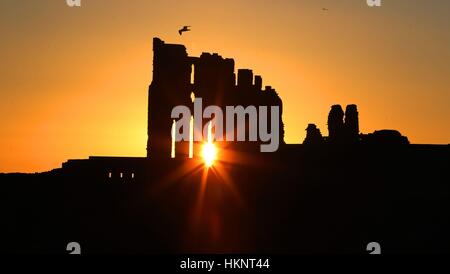 Die Sonne geht über Tynemouth Priory auf die an der Nordost-Küste. Stockfoto