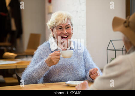 Lächelnde senior Frau hält Tasse. Stockfoto