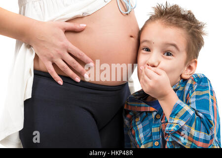 Porträt eines Kindes und einer schwangeren Frau. Das hört, was in Mutters Bauch vor sich geht. Foto closeup Stockfoto