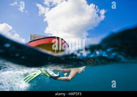 Ein Split-Shot einer Frau vor einem Bug eines Bootes schwimmen Stockfoto