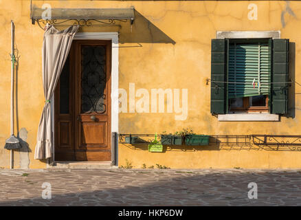 Foto einer bunten mediterranen Haus Fassade unter der warmen venezianischen Sonne in der Insel Burano. Stockfoto