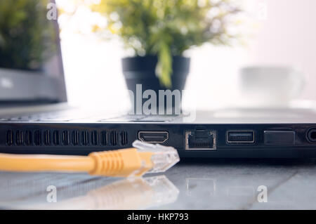 Laptop Wit LAN, HDMI und USB-Ports auf dem Schreibtisch Stockfoto