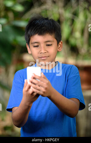 kleiner Junge mit Telefon so dass Videocall im park Stockfoto