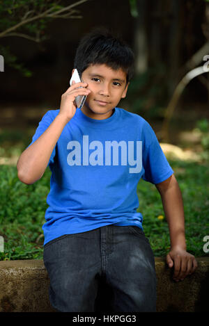 kleiner Junge sprechen im Telefon im grünen park Stockfoto