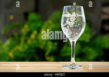 Champagner im Longdrinkglas auf Tabelle Park gießen Stockfoto