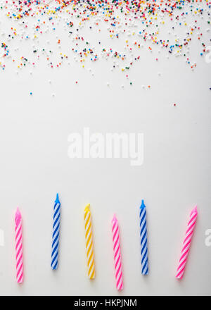 Hintergrund der Regenbogen unerreichten Streusel und Geburtstagskerzen auf Creme Untergrund Stockfoto
