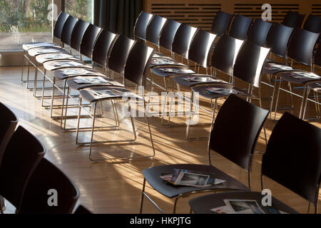 Starke Fensterlicht spielt auf Stühlen in einer Halle für eine Konferenz eingerichtet. Stockfoto