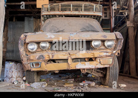 Staubige Oldtimer in der Garage geparkt. Kaputtes Auto, Vorderansicht. Stockfoto