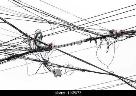 Die elektrischen Leitungen auf einem weißen Hintergrund. Elektrische Kabel gegen den Himmel mit Wolken in Asien. Linie Übertragungskabel, Thailand. Stockfoto