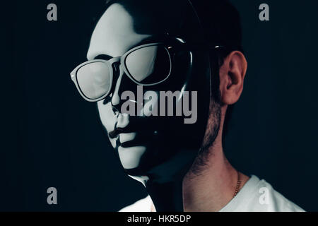 Mann in glänzend schwarzer Maske und eine Sonnenbrille. Horizontale Studioportrait in Nahaufnahme. Stockfoto
