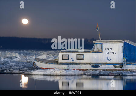 Januar 2017, Moonlight und kleinen Boot auf zugefrorenen Donau in Belgrad, Serbien Stockfoto