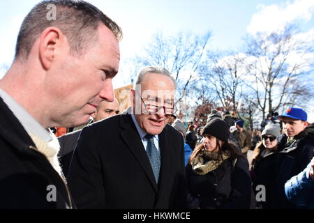 New York City, USA. 29. Januar 2017. US-Senator Charles Schumer plaudert mit Wähler auf seinem Weg aus Battery Park. Tausende von Aktivisten versammelten sich im Battery Park für einen Protest gegen die Trump Verwaltung Einwanderung & Reiseverbote aus sechs mehrheitlich muslimischen Ländern. Nach Ansprachen von Senator Charles Intrigant & Congressional repräsentative Nydia Velazquez u.a. Aktivisten marschierten durch die Straßen, Foley Quadrat im unteren Manhattan Credit: Andy Katz/Pacific Press/Alamy Live News Stockfoto