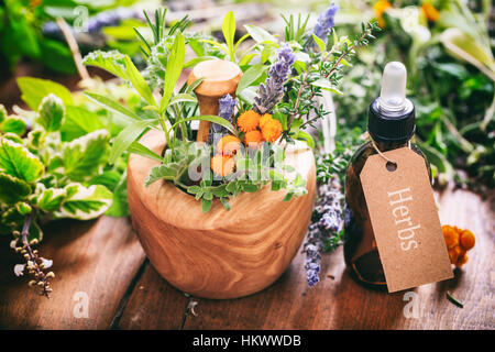 Kräutern, ätherischen Ölen und Mörtel auf einem hölzernen Hintergrund Stockfoto