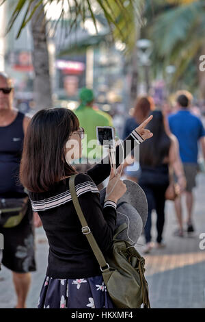 Japanische weibliche Touristen mit ihrem Smartphone zu verbinden und sprechen Sie mit ihrer Familie und Freunden zu Hause. Thailand-Südostasien Stockfoto