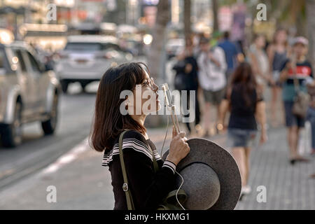 Japanische weibliche Touristen mit ihrem Smartphone zu verbinden und sprechen Sie mit ihrer Familie und Freunden zu Hause. Thailand-Südostasien Stockfoto