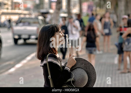 Japanische weibliche Touristen mit ihrem Smartphone zu verbinden und sprechen Sie mit ihrer Familie und Freunden zu Hause. Thailand-Südostasien Stockfoto