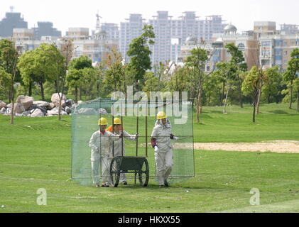 Frauen in einem Käfig Fuß über die driving-Range, Golfbälle, Tomson Golf Club sammeln BMW Asian Open 2004, Shanghai, China Stockfoto