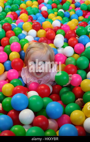 Baby, Kind spielen zu viele farbige Kugeln in einem Bällebad, erkunden entdecken, Baby learning Konzept, Baby Ball pit Stockfoto