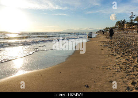Frau geht am Strand in der Nähe von Marbella bei Sonnenuntergang, Spanien Stockfoto