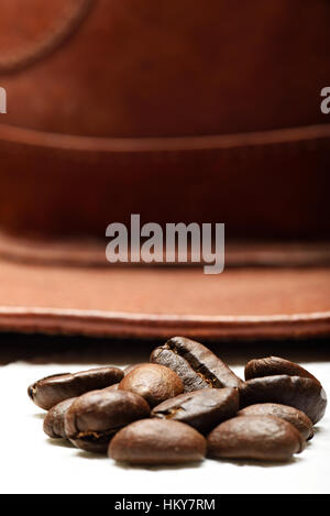 Nahaufnahme von Kaffeebohnen auf Leder Bauer Hut Hintergrund Stockfoto