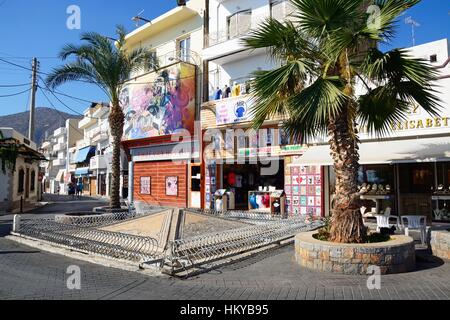 Blick auf den Roman Sarakino Brunnen entlang der Uferpromenade mit Souvenirläden auf der Rückseite, Hersonissos, Kreta, Griechenland, Europa. Stockfoto