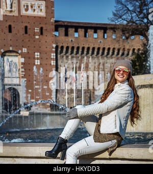 Die Wiederentdeckung der Dinge alle lieben in Mailand. In voller Länge Portrait von glücklich moderne touristische Frau vor Castello Sforzesco in Mailand, Italien sitzen ne Stockfoto